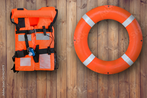 Obraz na płótnie Life buoy and life jacket hanging on wooden wall for emergency response when people sinking to water almost place near pool and beach w salonie