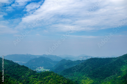 Landscape of Green mountain scenery is on the background of peaceful blue cloudy sky © Piyawan