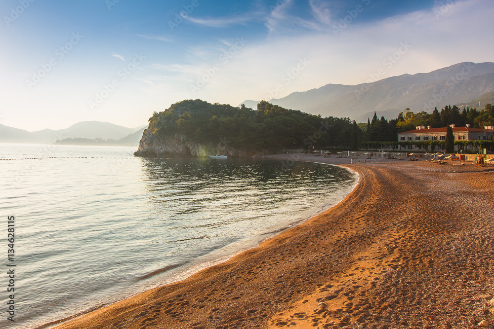 View of a rocky cliff near the Mediterranean sea and beach. Milocer Park. Coast Budva Riviera. Montenegro.