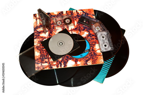 old vinyl records in a paper case, tape cassette and cd disk on white background