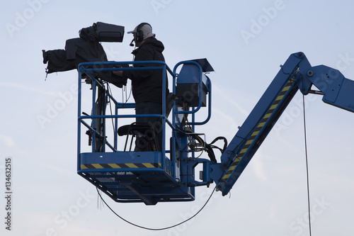 Fototapet The cameraman filming an outdoor sporting event from the crane in the air