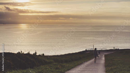 Clouds sky and sunlight sunset on horizon ocean. People on background seascape dramatic atmosphere rays sunrise. Relax view waves water sea  mockup nature evening concept perspective ocean sunrise