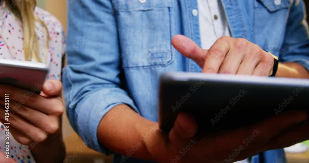 Group of business executives interacting over digital tablet and mobile phone in office 4k Group of business executives interacting over digital tablet and mobile phone in office 4k
