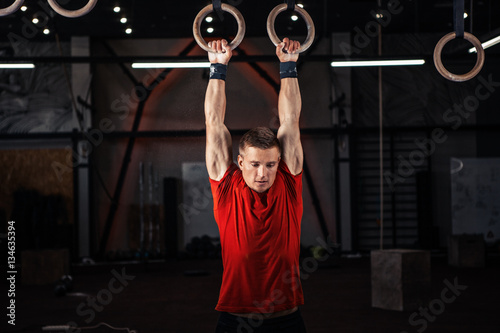 Athlete working out his muscles on rings