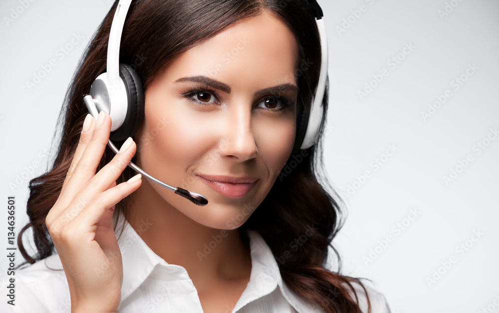 Portrait of customer support female phone worker, on grey Portrait of customer support female phone worker, on grey