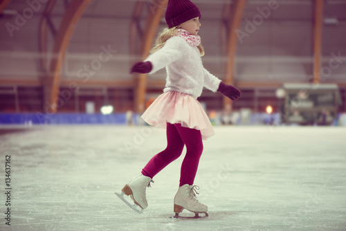 Pretty girl skates in a red cap, warm gloves and sweater © spass