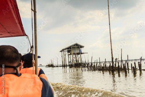 Tourist visiting the Hut in the sea that used for the owner to stay and guard his cockle farm in Samut Songkram, Thailand photo