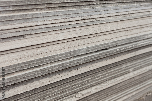 A side view on the Flat slate sheets stacked on each other. Material for construction. Close-up angle with blurred background