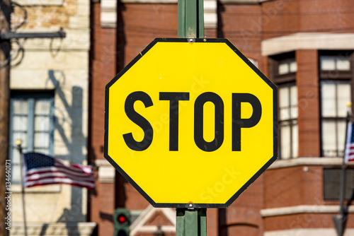 STOP -road sign with black latters on the yellow background in USA photo