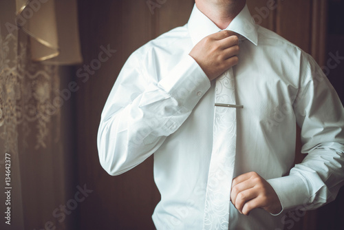 man straightens his tie 
