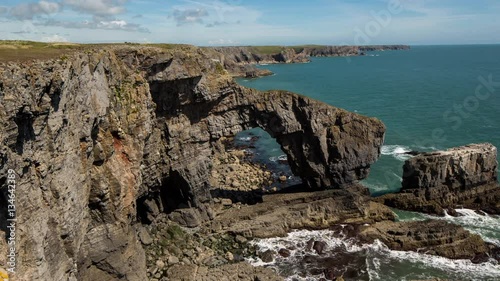 timelapse of the green bridge, a natural rock arch on the coast of pembrokeshire, wales, UK photo