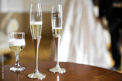 Champagne flutes with steel legs stand on wooden table