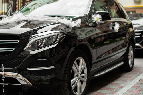 Black Mercedes G-Class decorated with white bows and flowers for