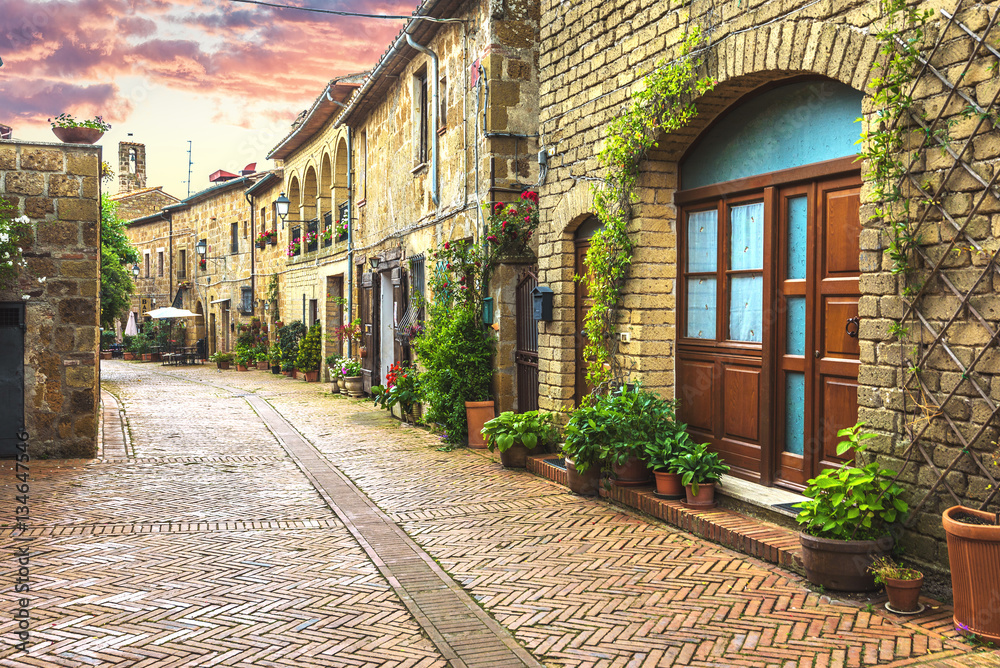 Obraz premium Kwiatowe uliczki starego włoskiego miasta w Toskanii.