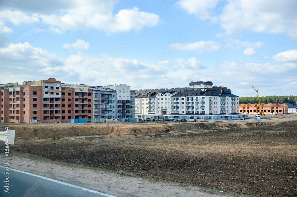 BELARUS, MINSK - APRIL 07/2015: Workers erected a residential complex on the field.