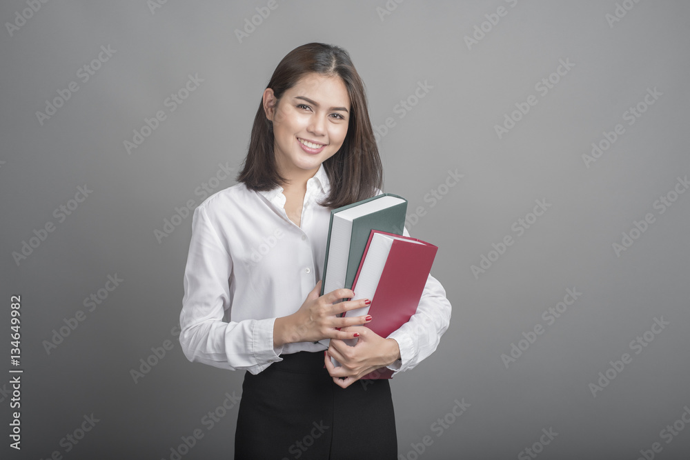 Beautiful teacher Woman holding book on grey background Beautiful teacher Woman holding book on grey background