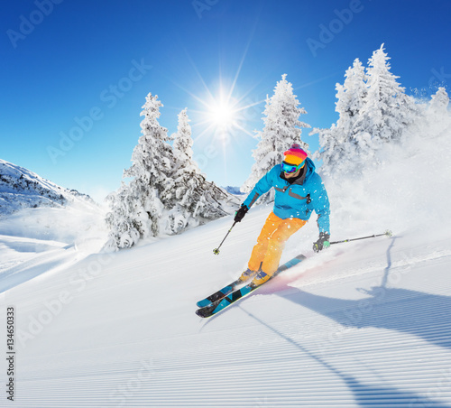 Skier on piste running downhill