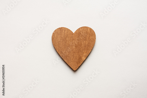 One Wooden Brown Heart On White Paper Background Texture.