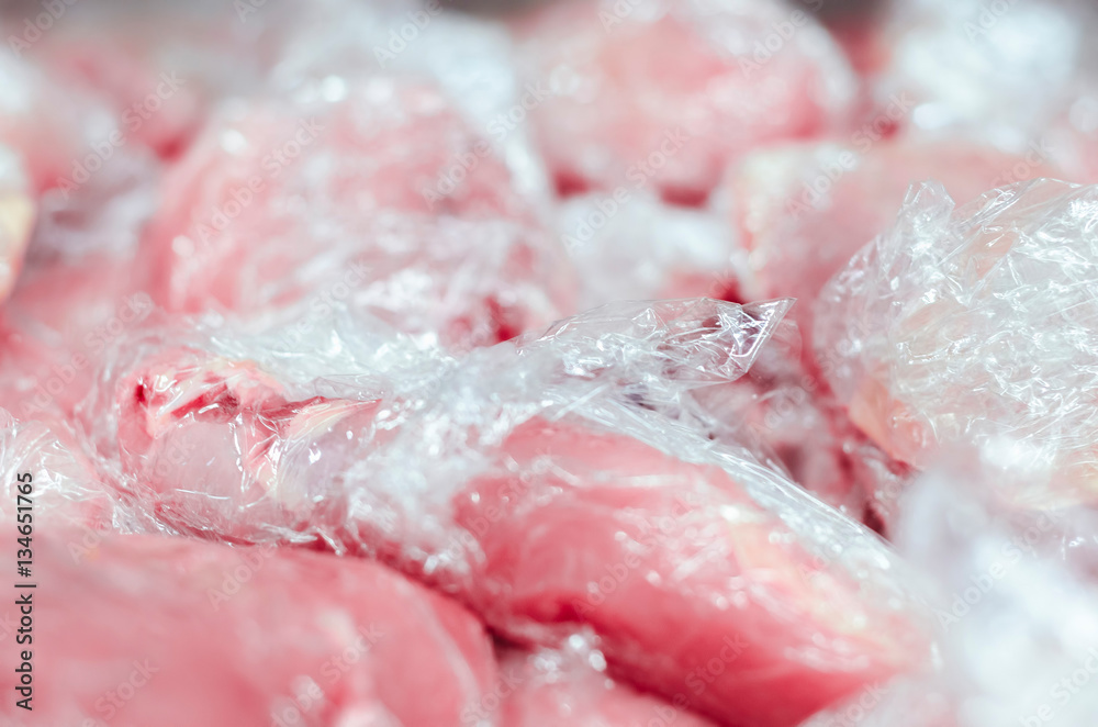 Pile of raw chicken meat in plastic wrap details Pile of raw chicken meat in plastic wrap details