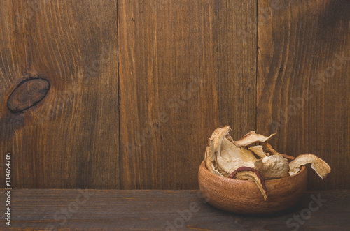 dried mushrooms in a wooden bowl on a wooden background/dried mushrooms in a wooden bowl