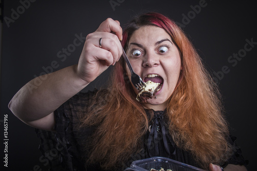 Foto Obese woman eating cake lustfully, eating disorder