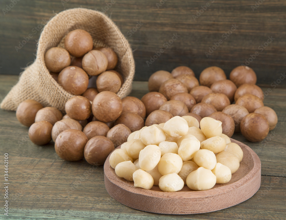 Organic Macadamia nut on wooden table (Macadamia integrifolia) Organic Macadamia nut on wooden table (Macadamia integrifolia)
