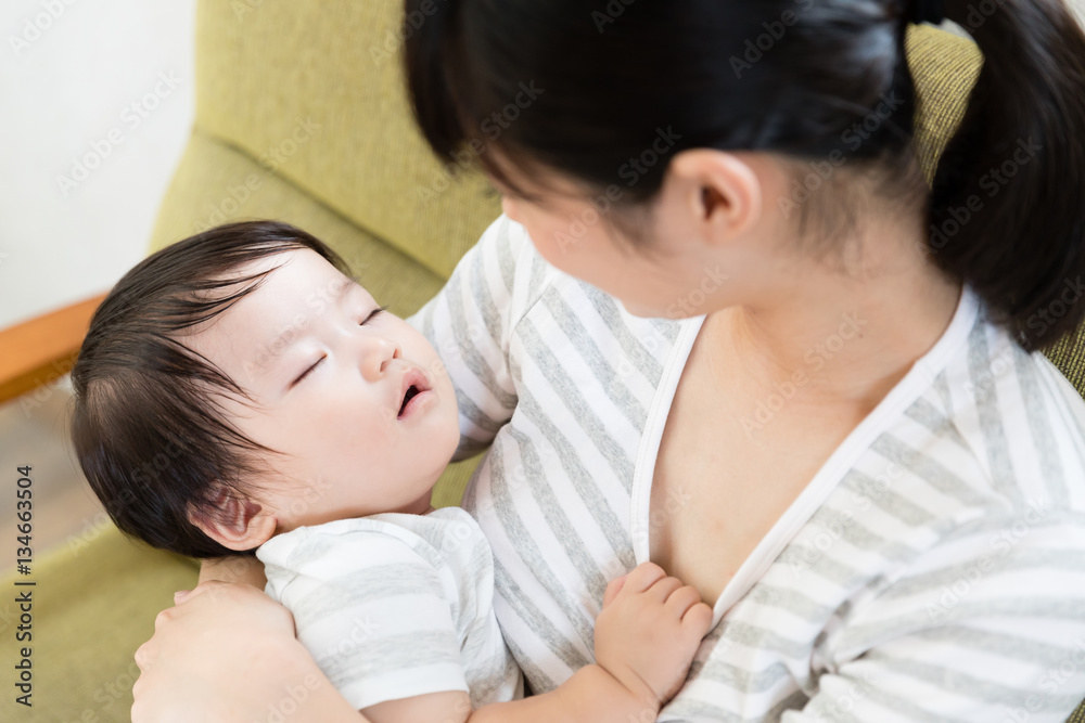 asian mother and baby relaxing on the sofa asian mother and baby relaxing on the sofa