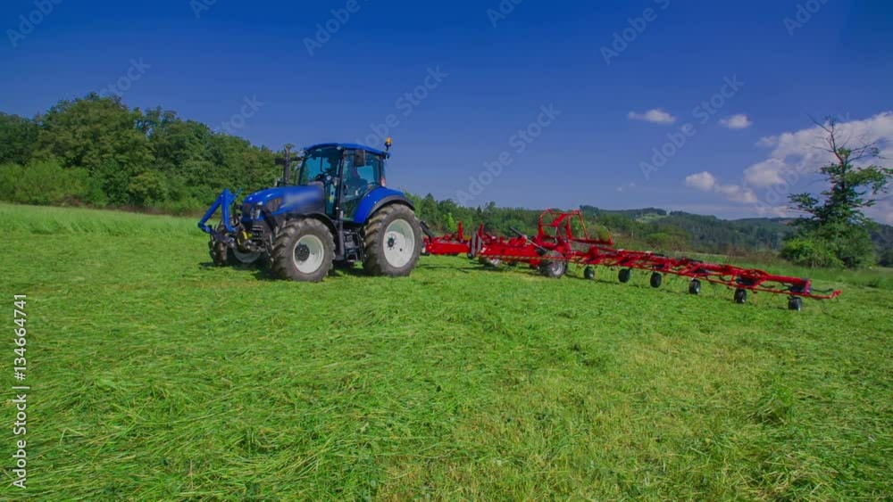 Rotary rakes machinery which is connected to a tractor are standing on the big grass field and rotary rakes are moving very fast.
Rotary rakes machinery which is connected to a tractor are standing on the big grass field and rotary rakes are moving very fast.