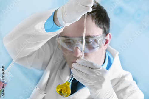 Young male scientist making...