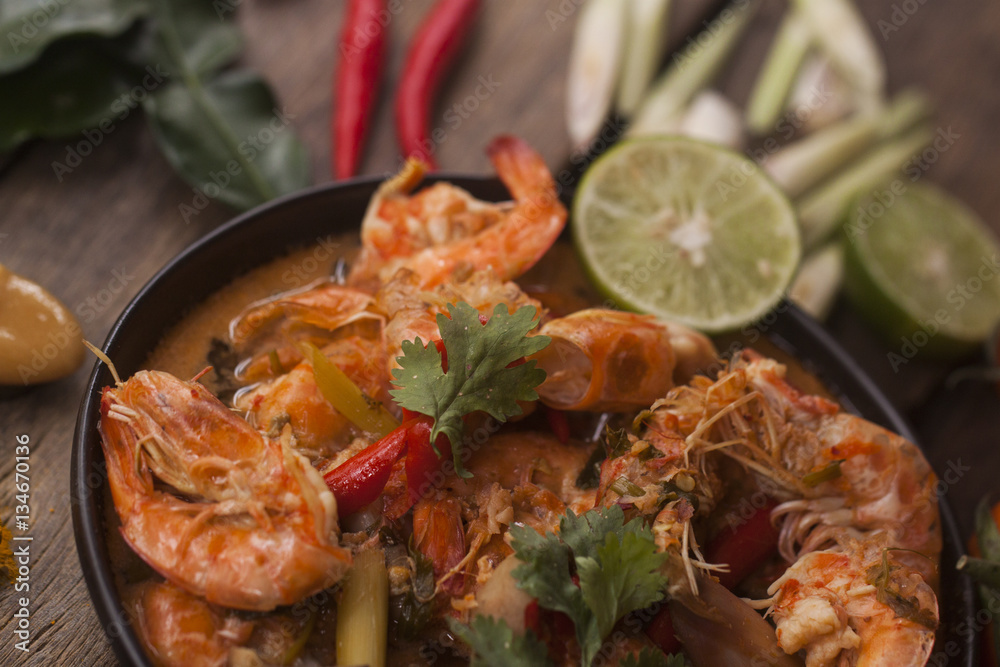 Tom Yam Kung ,Prawn and lemon grass spicy soup with mushrooms,thai food in wooden bowl on top view Tom Yam Kung ,Prawn and lemon grass spicy soup with mushrooms,thai food in wooden bowl on top view