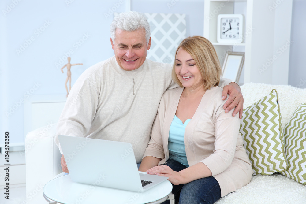 Grandparents using laptop at home