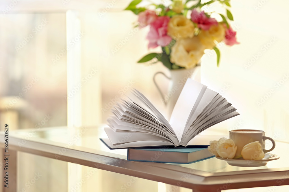 Fototapeta premium New books on table with cup of coffee