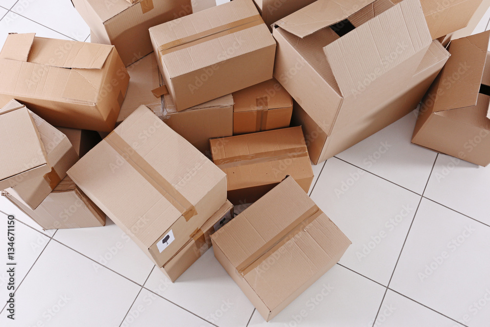 House move concept. Carton boxes on tile floor background House move concept. Carton boxes on tile floor background