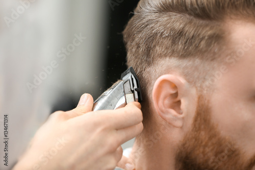 Barber making modern male hairstyle