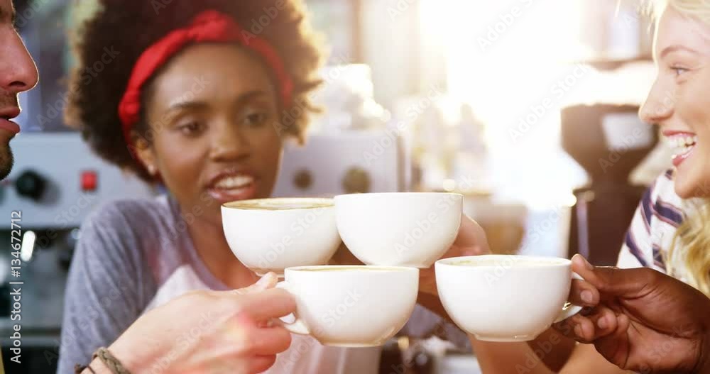 Group of happy friends holding cup of coffee in café 4k Group of happy friends holding cup of coffee in café 4k