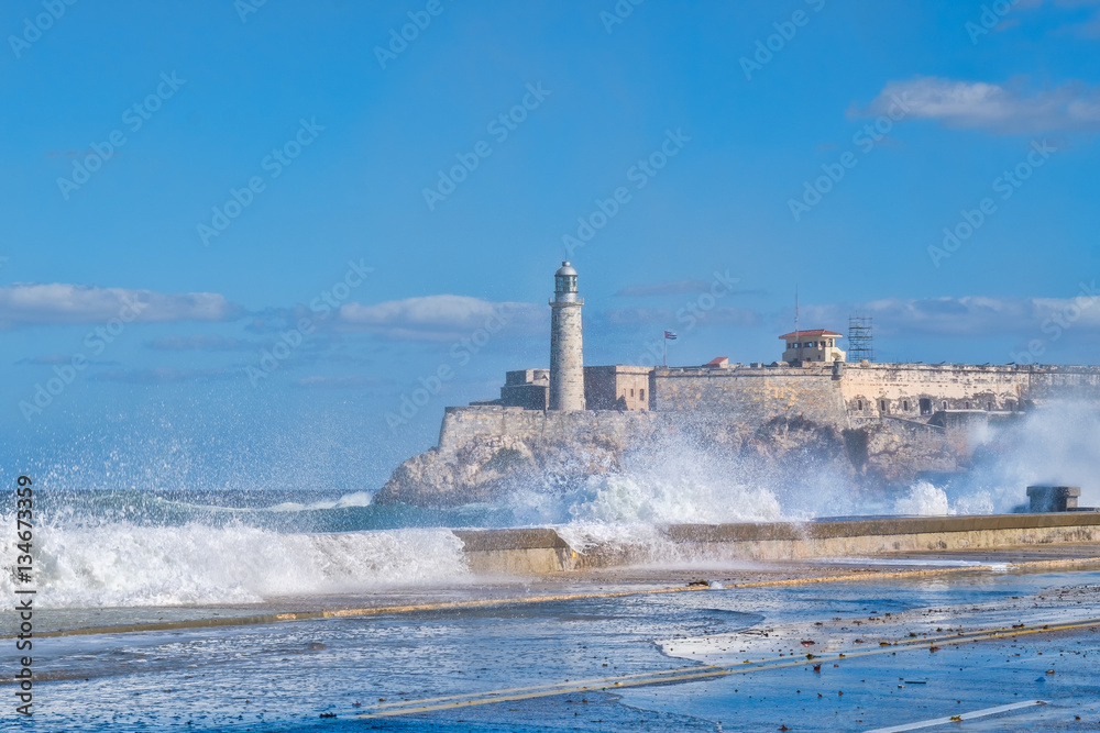 The fortress and lighthouse of El Morro in Havana with sea waves crshing on the seawall