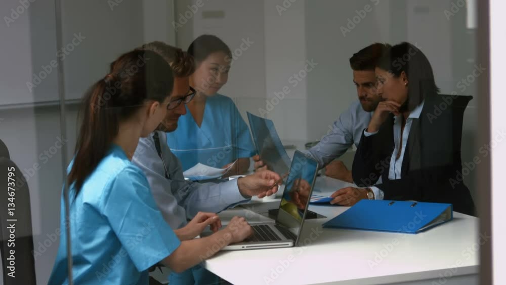 Doctors discussing over laptop in conference room 4k Doctors discussing over laptop in conference room 4k