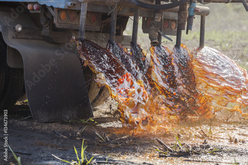 Truck pouring molasses in the sugar plantation as fertilizer photo