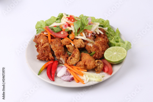 Spicy deep-fried chicken salad with roll green mango . © smilekorn