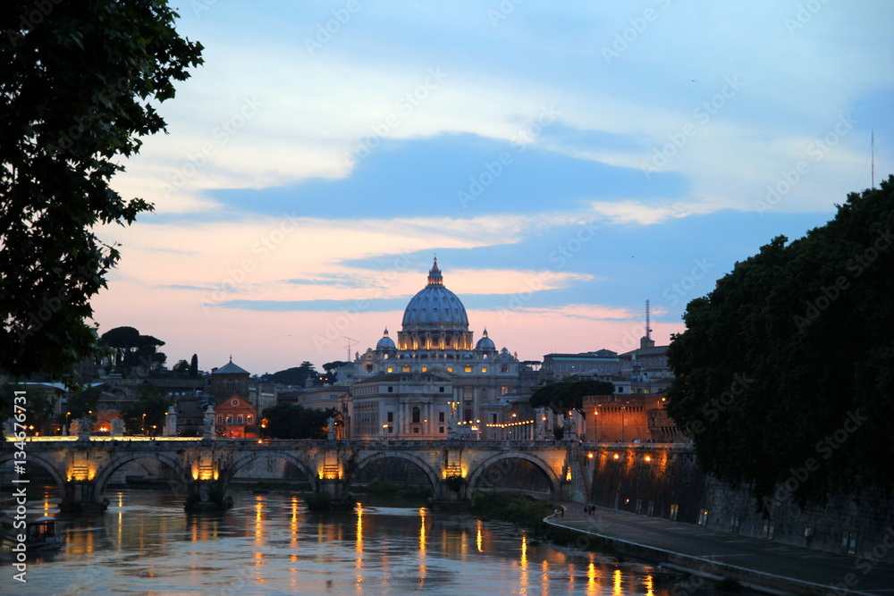 Rome. Italy. The sunset view on a river, a bridge and a cathedral. 