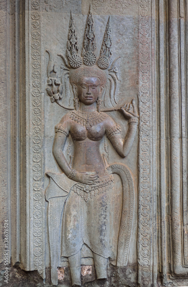 Naklejka premium Stone carving of an angel or Apsara on the wall of Angkor Wat, the 12th century Hindu temple complex in Cambodia