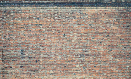 The texture of wall from a variety of old and dirty brick. Detailed pattern of a plurality of different sizes of brick red worn out photo