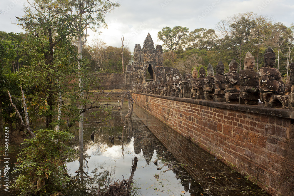 Bridge with statues and ancient gate near Angkor Wat 