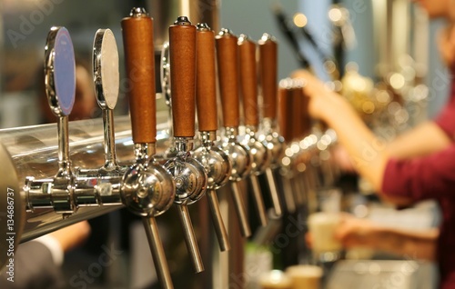 Fotografía metal taps with the wooden handle for draft beer in the pub