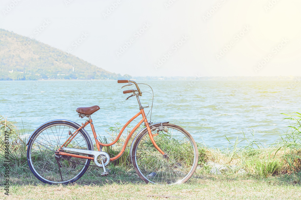 Orange bicycle with the backdrop of the mountains and the sea wi Orange bicycle with the backdrop of the mountains and the sea wi