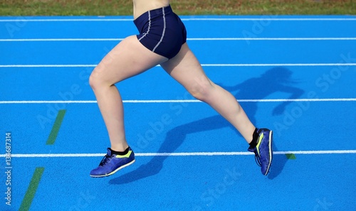 legs of young female runner running on athletic track © ChiccoDodiFC