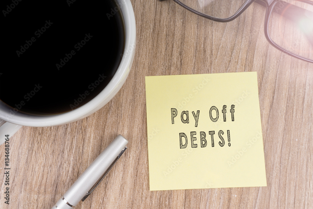PAY OFF DEBTS! text on yellow note PAY OFF DEBTS! text on yellow note