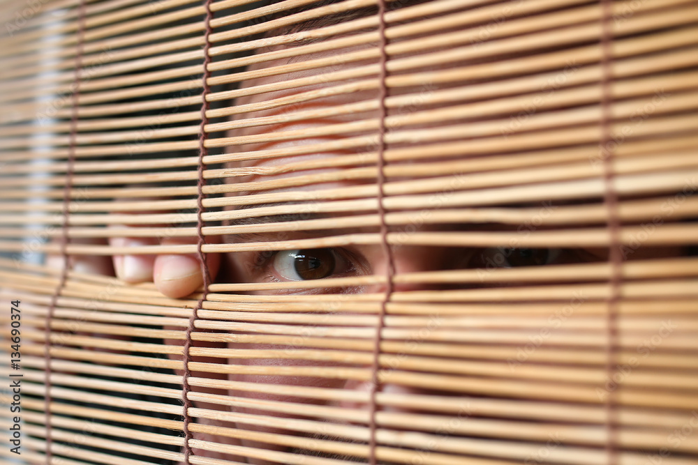 Naklejka premium eyes looking through the blinds