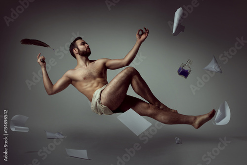 Half naked handsome man poet levitating with his literary things photo