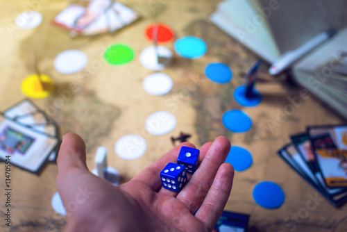 hand throws the dice on background world map Board games